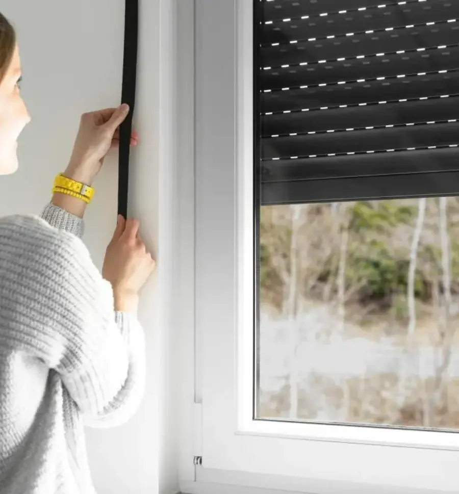 Femme actionnant l'interrupteur d'un volet roulant électrique